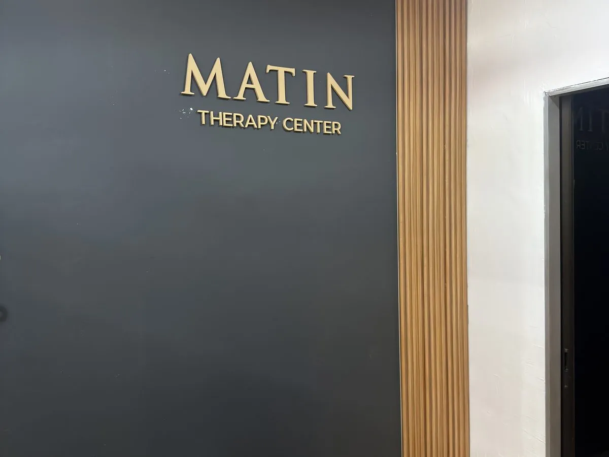 Renovated treatment room detail — wall branding and recovery bed (IMG_1064, centre crop 4:3)